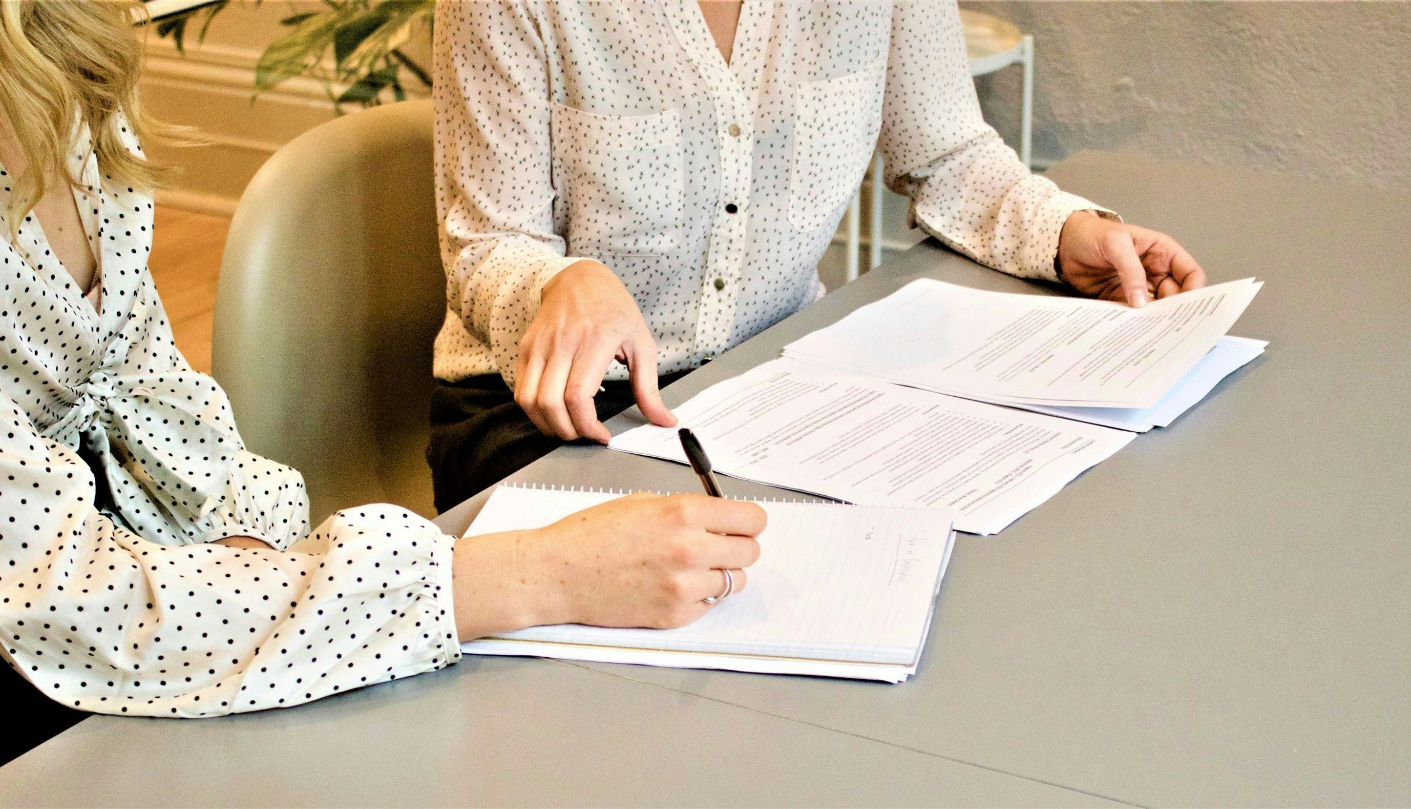 Kvinner som underskriver dokumenter.