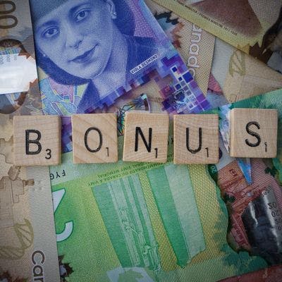 "Bonus" skrevet i Scrabble-brikker over penger.