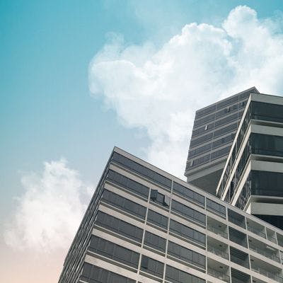Bilde av kontorbygning med lyse skyer over.